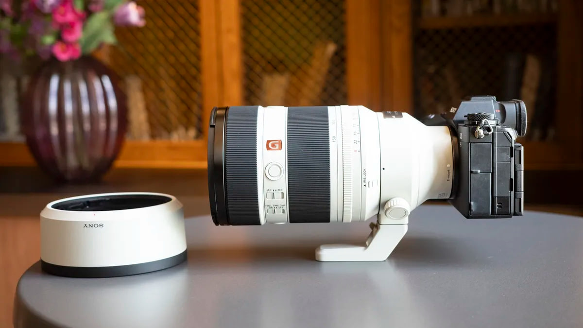 لنز سونی ۵۰-۱۵ جی مستر با پایه روی میز